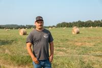 Man in t-shirt and jeans standing in a field