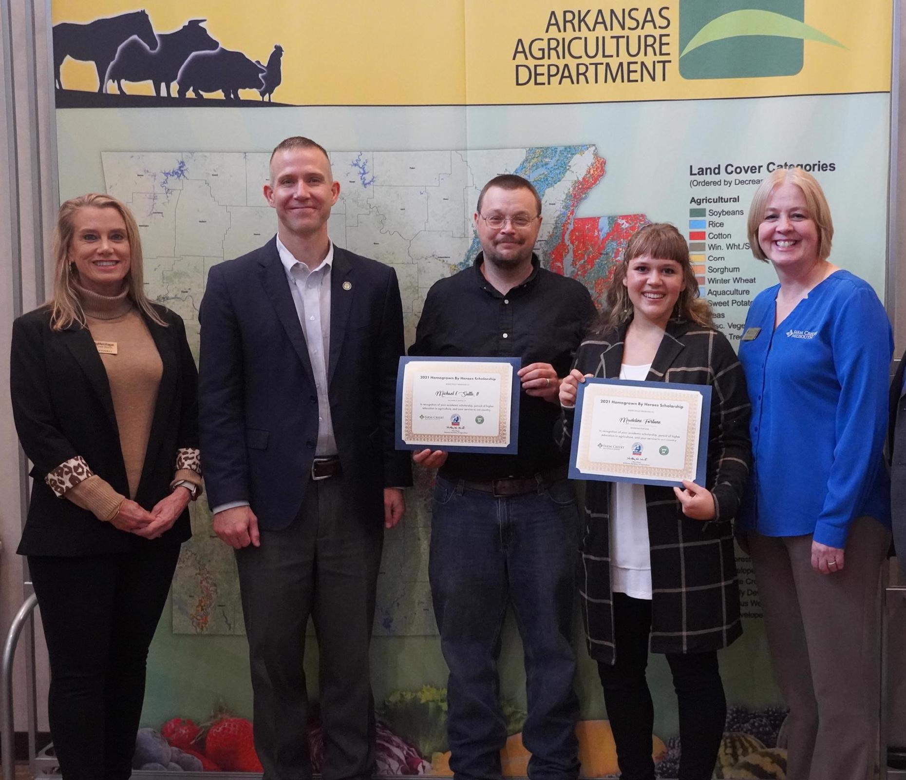Arkansas Secretary of Agriculture Wes Ward presenting scholarship awards to two HomeGrown by Heroes scholarship winners