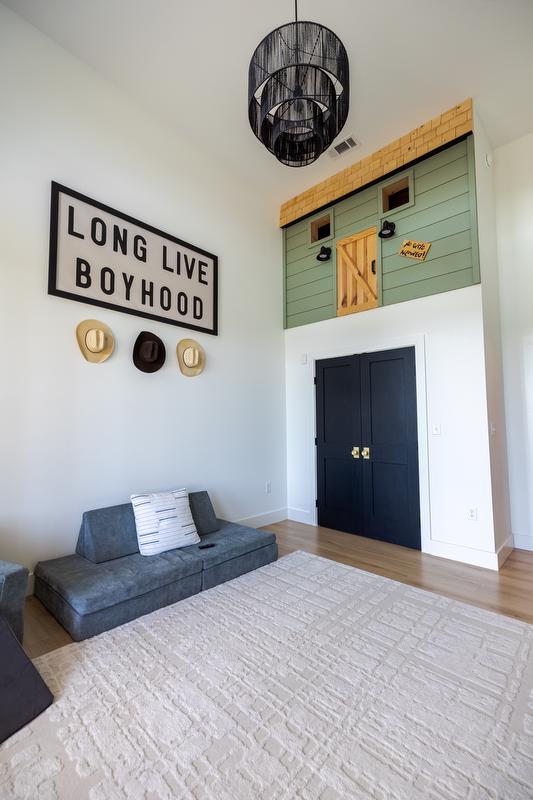Kids' playroom with built in "tree house" and floor seating. Wall sign reads "long live boyhood"
