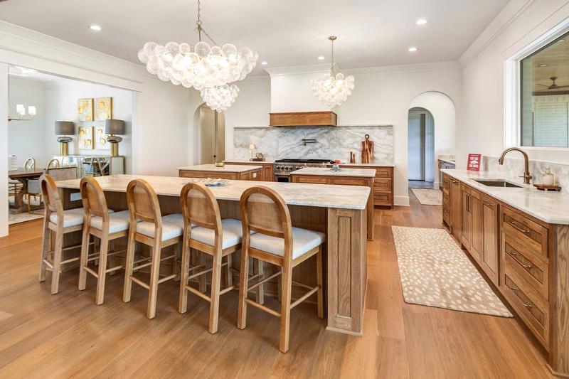 Designed for gathering, the kitchen features a large serving island and two additional prep islands at its center. 