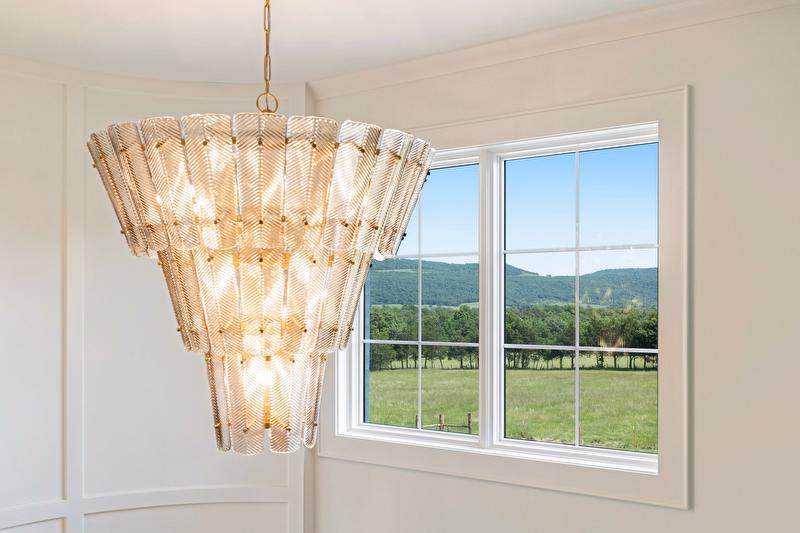 Natural light pours through oversized windows, creating panoramic views across the property. 