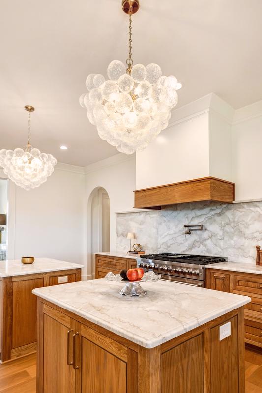 Designed for gathering, the kitchen features a large serving island and two additional prep islands at its center. 