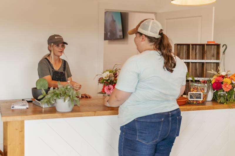 Courtney Witt helps a customer inside Blossomberry Nursery's storefront