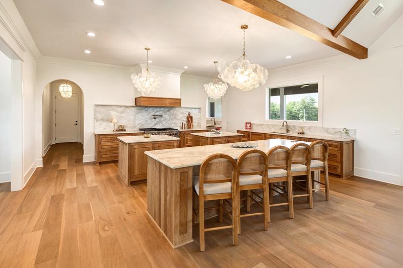 Designed for gathering, the kitchen features a large serving island and two additional prep islands at its center. 