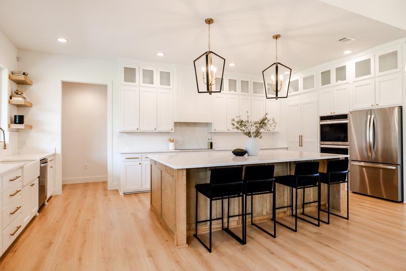 Greene family kitchen. Bright and airy accents of black and large island in the middle.