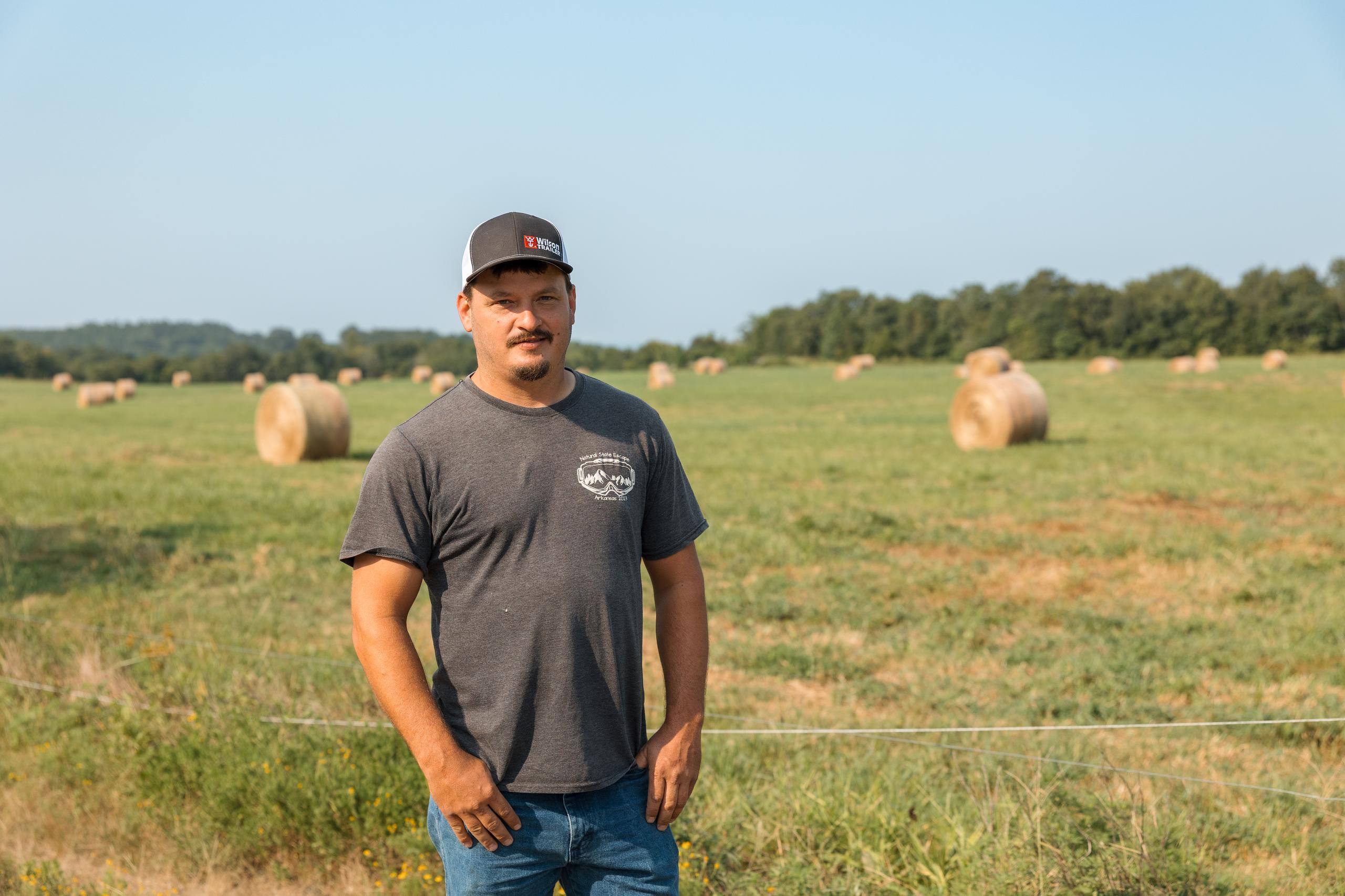 Man in t-shirt and jeans standing in a field