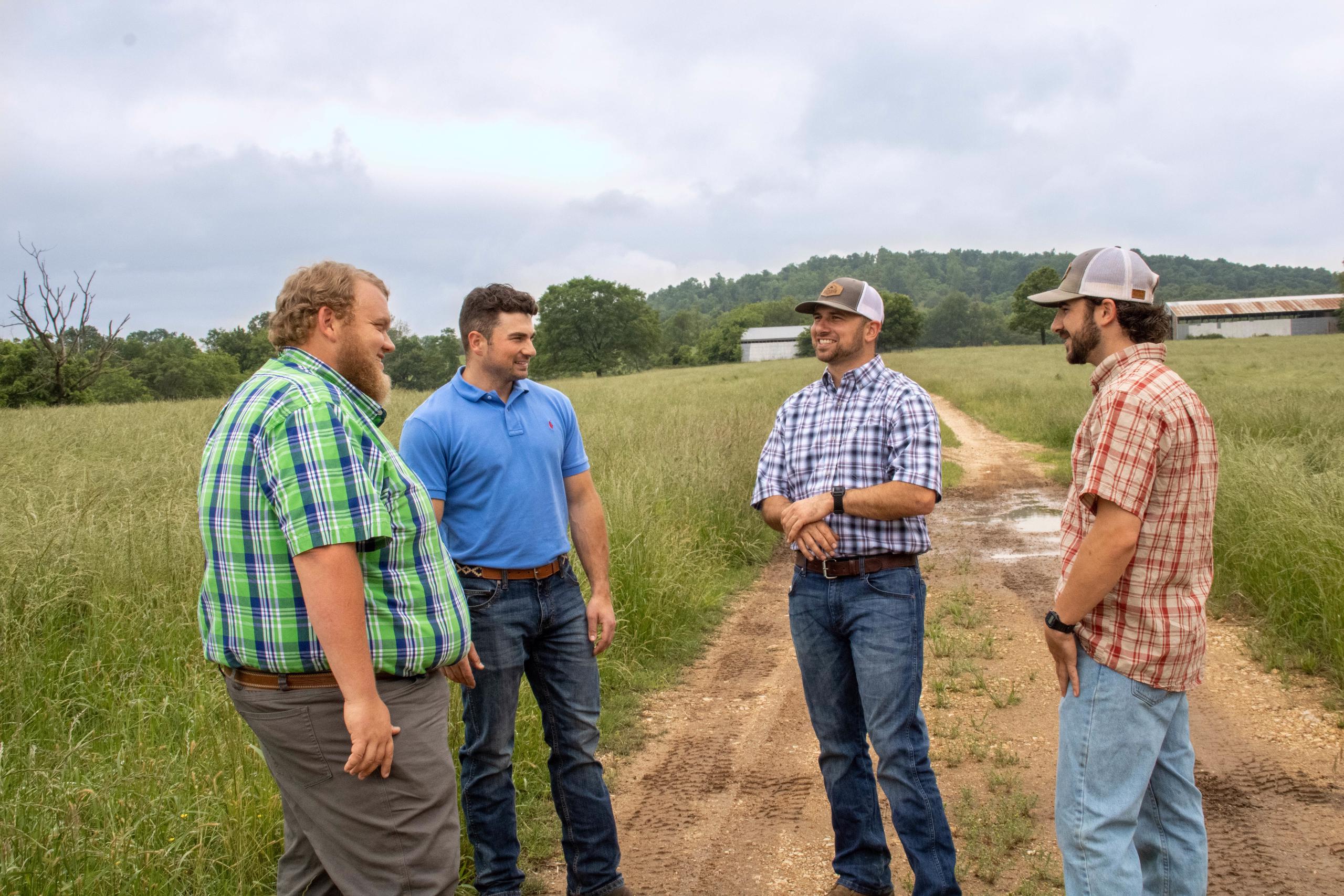 Four people standing in field