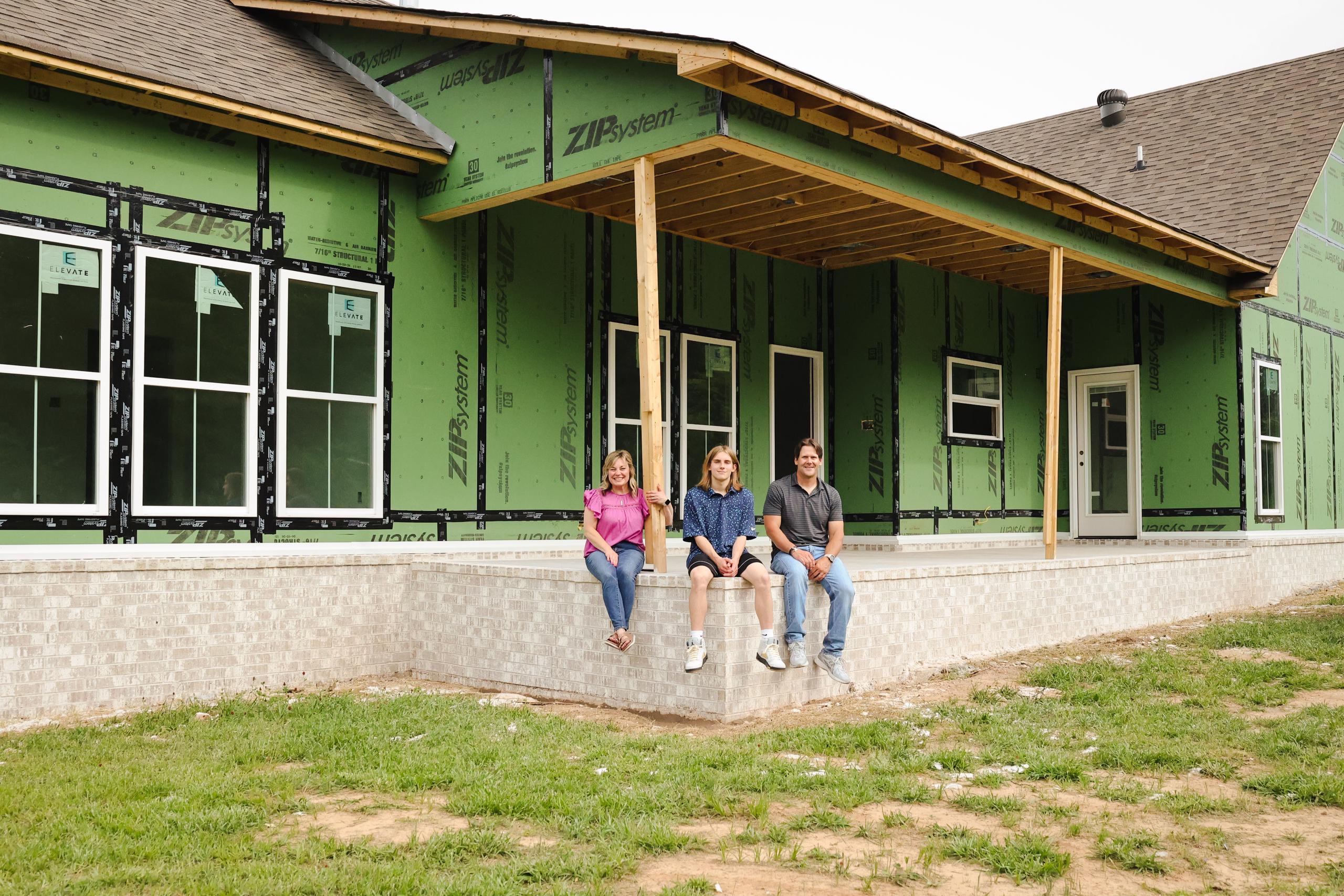 Mourot family in front of their partially constructed home