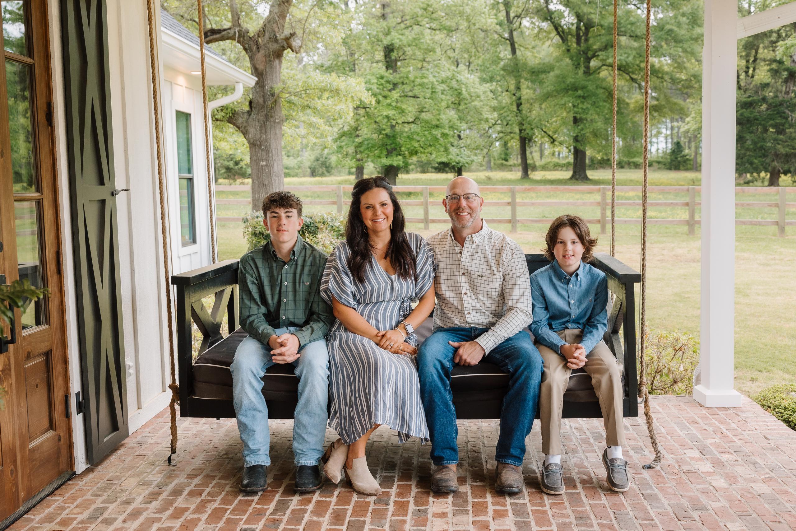 Talley family poses on their front porch swing.